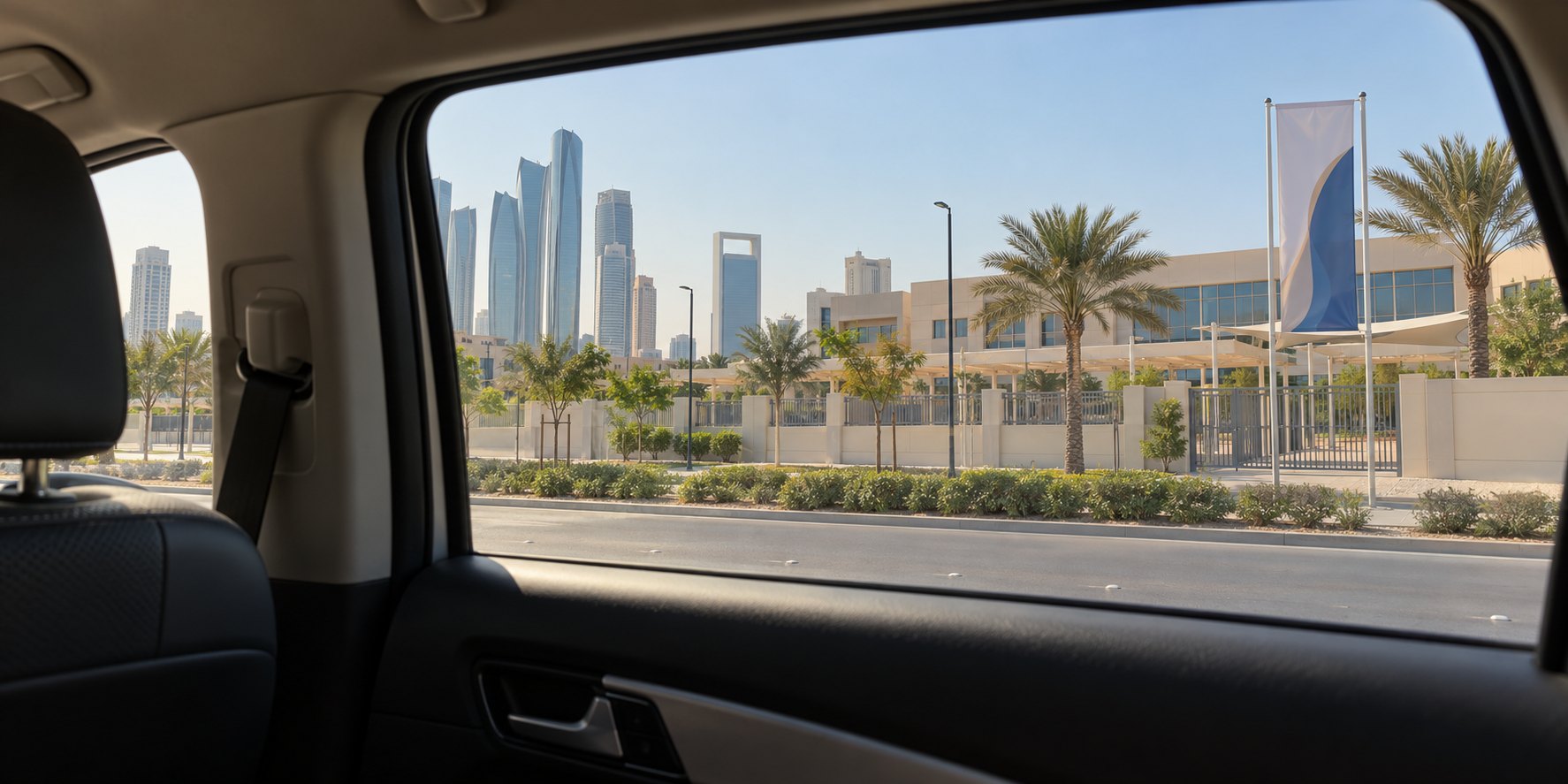 A school campus and Abu Dhabi skyline seen through a taxi window